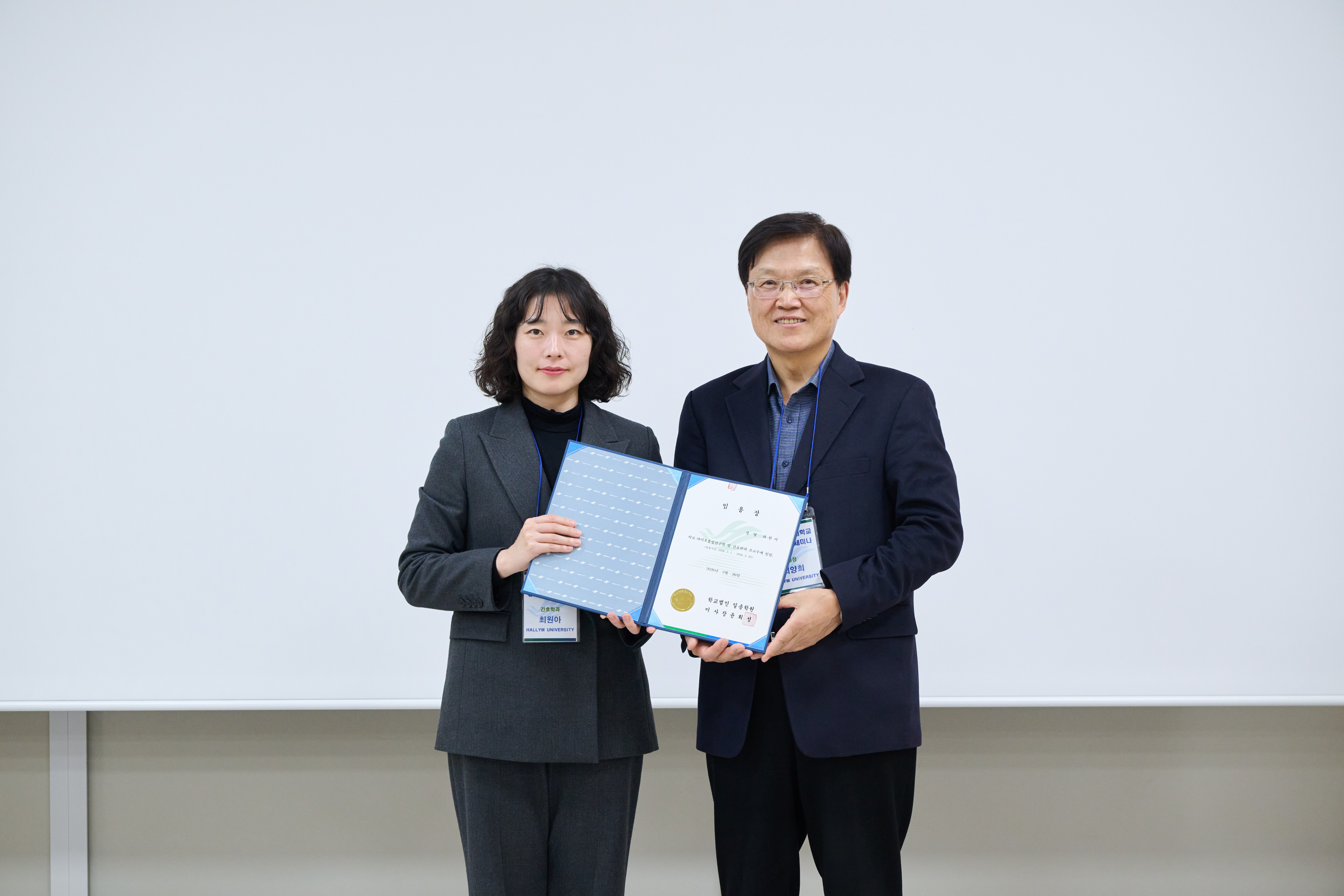 최원아 교수(왼쪽)가 최양희 한림대학교 총장(오른쪽)과 임용장을 들고 정면을 바라보고 있다.